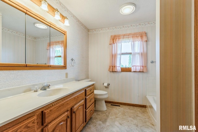 404 10th St, Lowden, IA 52255 - bathroom featuring vanity, healthy amount of natural light, toilet, and baseboards