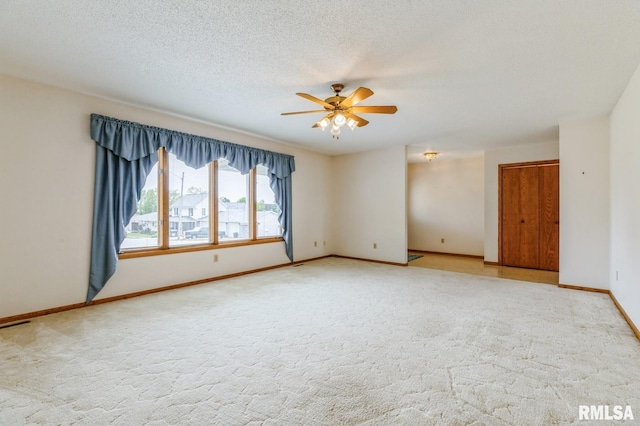 404 10th St, Lowden, IA 52255 - carpeted empty room featuring ceiling fan, baseboards, and a textured ceiling