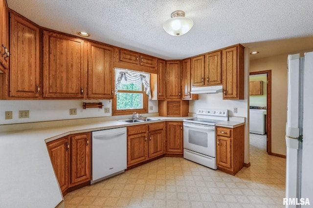 404 10th St, Lowden, IA 52255 - kitchen with white appliances, under cabinet range hood, washer / clothes dryer, a sink, and brown cabinetry