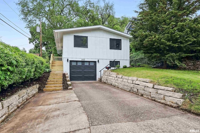 2402 Middle Rd, Davenport, IA 52803 - view of front of home with stairway, a garage, asphalt driveway, board and batten siding, and brick siding