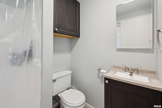 716 10th St, De Witt, IA 52742 - bathroom featuring vanity, toilet, a shower, and baseboards
