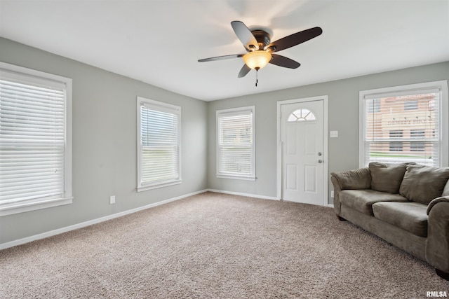 716 10th St, De Witt, IA 52742 - carpeted living room with a ceiling fan, baseboards, and healthy amount of natural light