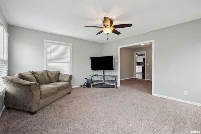 716 10th St, De Witt, IA 52742 - carpeted living room featuring a ceiling fan and baseboards