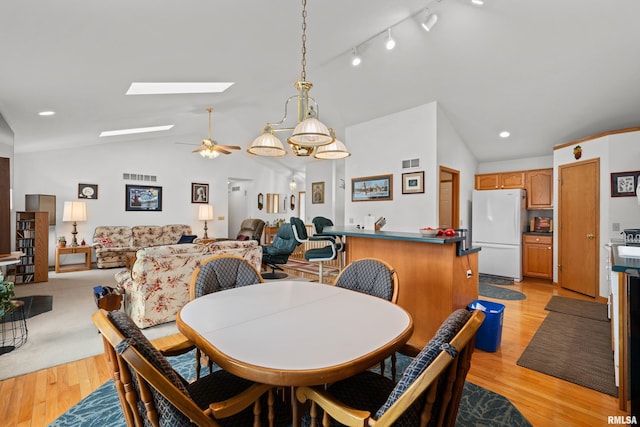 5142 Fillmore Ct, Davenport, IA 52806 - dining space featuring a skylight, light wood-style floors, a ceiling fan, track lighting, and high vaulted ceiling