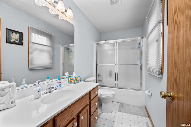 5142 Fillmore Ct, Davenport, IA 52806 - bathroom with vanity, toilet, tile patterned floors, and shower / bath combination with glass door