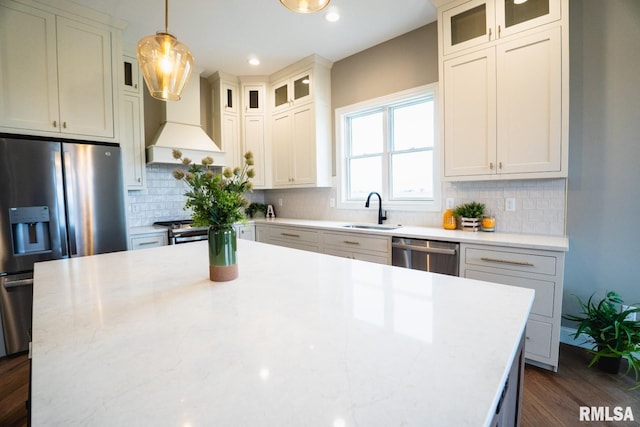 6654 Meghan Ave, Bettendorf, IA 52722 - kitchen featuring appliances with stainless steel finishes, custom range hood, a sink, dark wood-type flooring, and a kitchen island