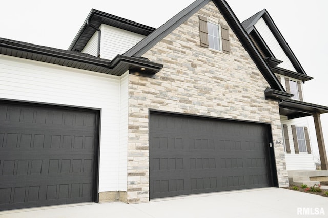 6654 Meghan Ave, Bettendorf, IA 52722 - view of property exterior featuring a garage, stone siding, and driveway