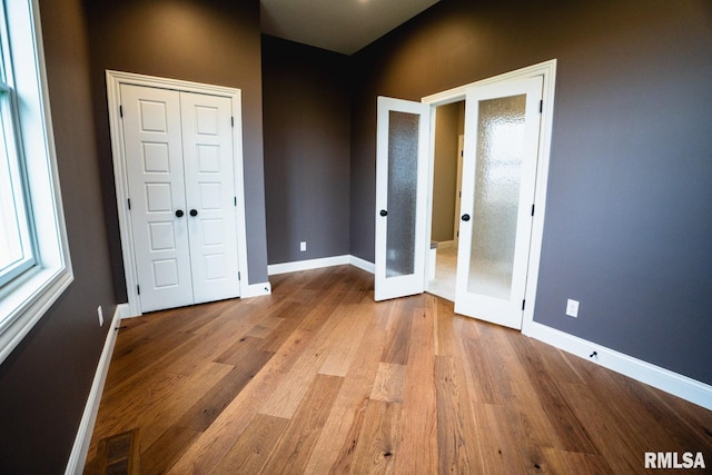 6654 Meghan Ave, Bettendorf, IA 52722 - unfurnished bedroom with french doors, wood finished floors, and baseboards