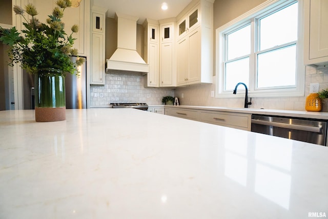 6654 Meghan Ave, Bettendorf, IA 52722 - kitchen featuring premium range hood, stainless steel appliances, a sink, light countertops, and decorative backsplash