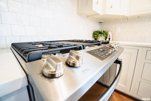 6654 Meghan Ave, Bettendorf, IA 52722 - kitchen view of tasteful backsplash, white cabinetry, light countertops, and stainless steel stove