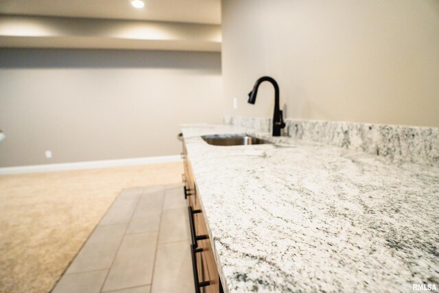 6654 Meghan Ave, Bettendorf, IA 52722 - kitchen with a sink, light carpet, recessed lighting, light stone counters, and baseboards