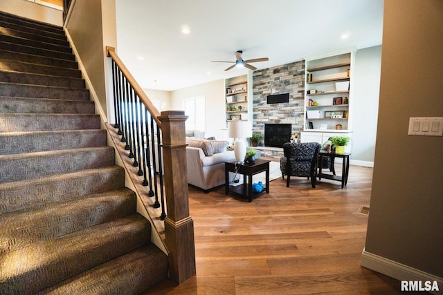 6654 Meghan Ave, Bettendorf, IA 52722 - living room with stairs, ceiling fan, baseboards, a fireplace, and wood finished floors