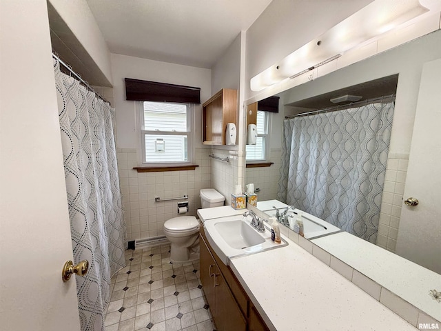 10 Blackhawk Hills Ct, Rock Island, IL 61201 - bathroom featuring tile walls, toilet, vanity, tile patterned floors, and a wainscoted wall