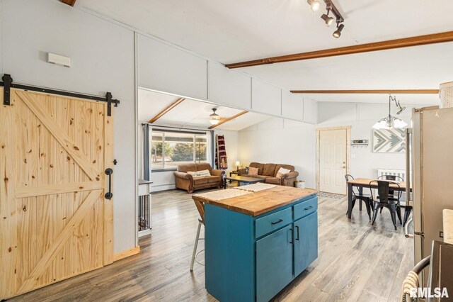944 45th St, New Boston, IL 61272 - kitchen with butcher block countertops, blue cabinets, light wood-style floors, freestanding refrigerator, and a kitchen breakfast bar