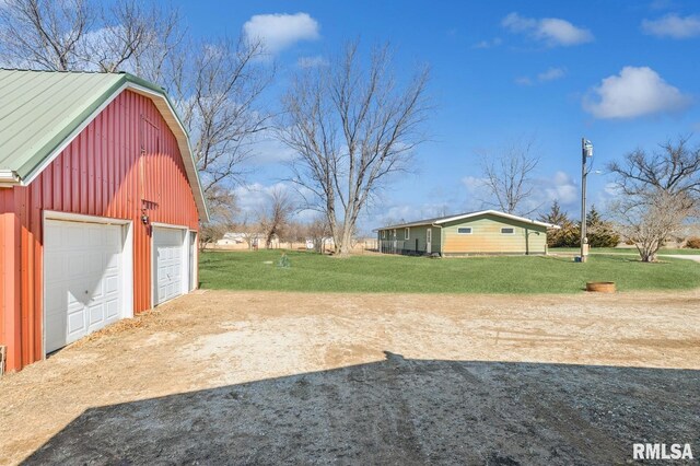 944 45th St, New Boston, IL 61272 - view of grassy yard featuring driveway, an outbuilding, and a garage