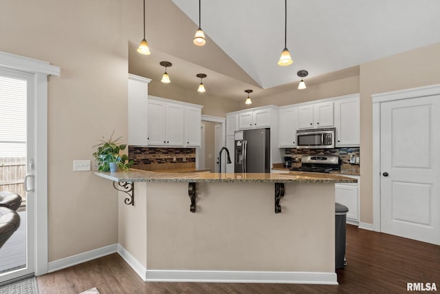 3484 Field Sike Dr, Bettendorf, IA 52722 - kitchen with appliances with stainless steel finishes, tasteful backsplash, a kitchen breakfast bar, a peninsula, and high vaulted ceiling