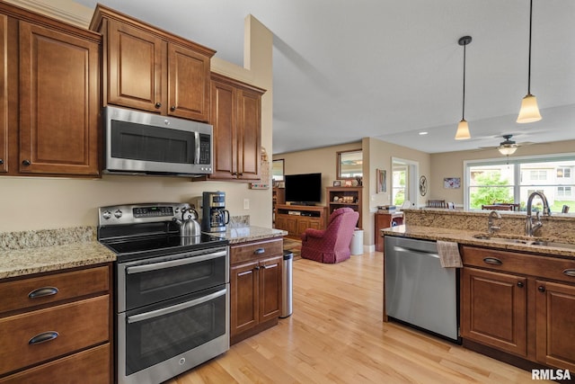 3608 Glengevlin Way, Bettendorf, IA 52722 - kitchen with stainless steel appliances, a sink, light wood-style floors, hanging light fixtures, and a ceiling fan