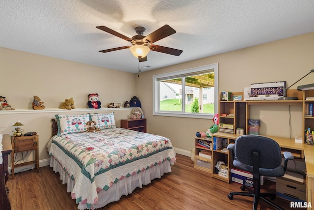 3608 Glengevlin Way, Bettendorf, IA 52722 - bedroom featuring baseboards, wood finished floors, a desk, a textured ceiling, and ceiling fan