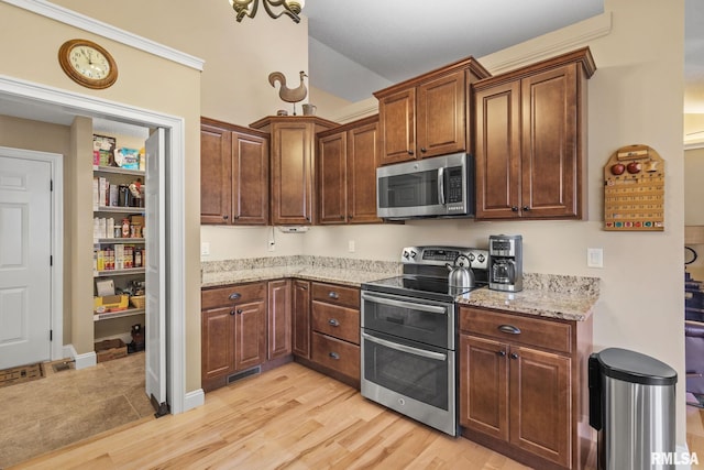 3608 Glengevlin Way, Bettendorf, IA 52722 - kitchen featuring stainless steel appliances, light stone countertops, light wood-style flooring, and lofted ceiling