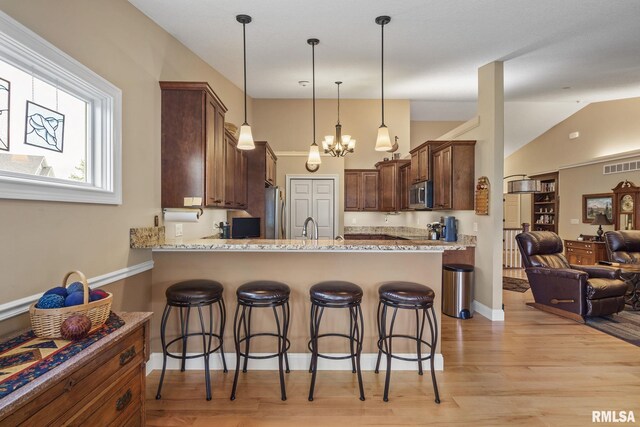 3608 Glengevlin Way, Bettendorf, IA 52722 - kitchen with appliances with stainless steel finishes, a sink, open floor plan, a breakfast bar, and lofted ceiling