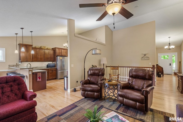 3608 Glengevlin Way, Bettendorf, IA 52722 - living room featuring lofted ceiling, light wood-style flooring, a chandelier, and a ceiling fan