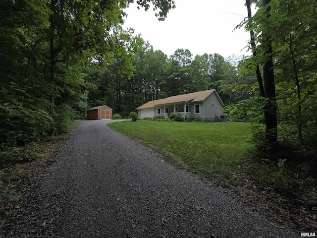 179 Hazel Rd, Simpson, IL 62985 - ranch-style house with a front lawn, gravel driveway, a forest view, and an attached garage