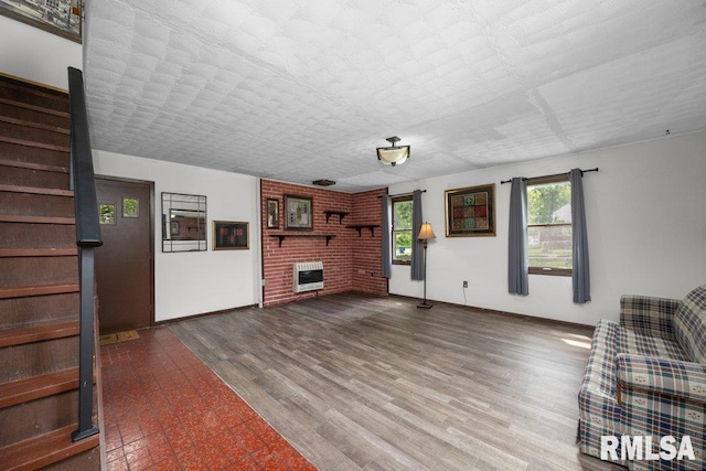 1240 Spruce St, Buffalo, IA 52728 - unfurnished living room with heating unit, stairway, a brick fireplace, and baseboards
