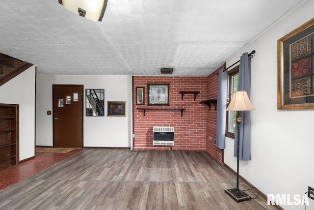1240 Spruce St, Buffalo, IA 52728 - unfurnished living room featuring heating unit, wood finished floors, a fireplace, and baseboards