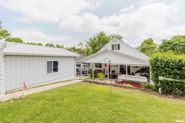 1408 Newton Ave, Johnston City, IL 62951 - view of front of home with board and batten siding, a hot tub, a front lawn, and metal roof