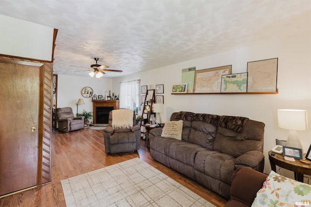 1408 Newton Ave, Johnston City, IL 62951 - living area with wood finished floors, a ceiling fan, a fireplace, and a textured ceiling