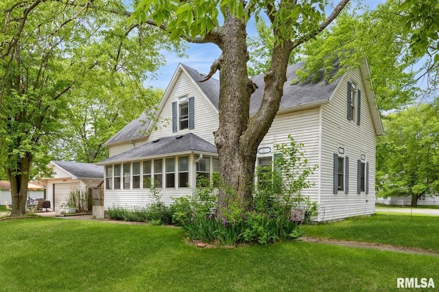 201 4th St, New Boston, IL 61272 - view of front of house with a sunroom, a front yard, and roof with shingles