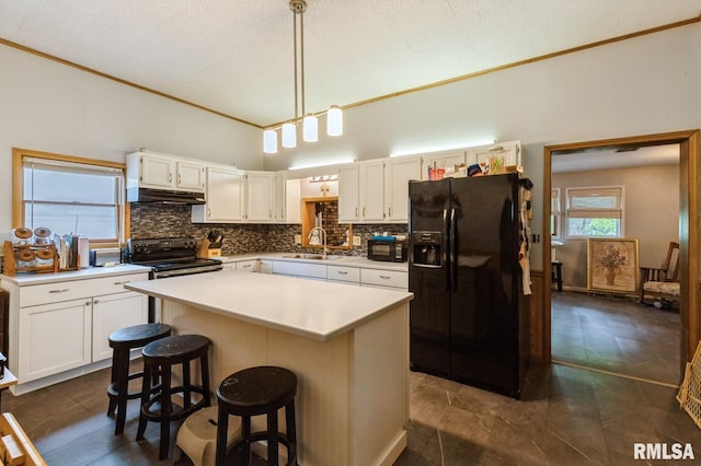 201 4th St, New Boston, IL 61272 - kitchen featuring black appliances, under cabinet range hood, backsplash, crown molding, and light countertops