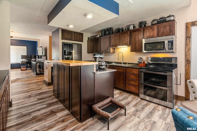 611 E Grand Ave, Carterville, IL 62918 - kitchen with stainless steel appliances, a sink, light wood-style floors, and wooden counters