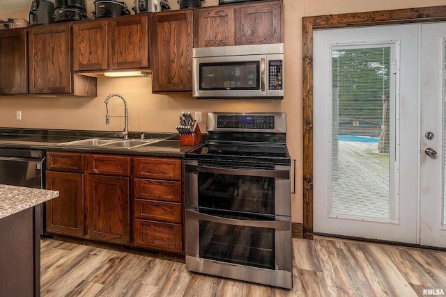 611 E Grand Ave, Carterville, IL 62918 - kitchen featuring stainless steel appliances, a sink, light wood-style floors, and dark countertops