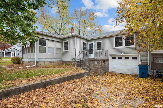 519 2nd St, Camanche, IA 52730 - rear view of property with a chimney and an attached garage