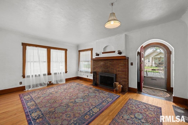 2446 16th Ave, Moline, IL 61265 - living area with plenty of natural light, a fireplace, wood finished floors, a textured ceiling, and baseboards