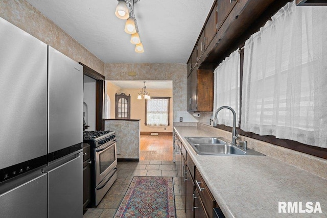 2446 16th Ave, Moline, IL 61265 - kitchen with appliances with stainless steel finishes, a sink, light countertops, a chandelier, and decorative light fixtures