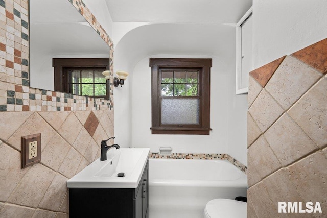 2446 16th Ave, Moline, IL 61265 - full bath with vanity, a garden tub, toilet, and plenty of natural light