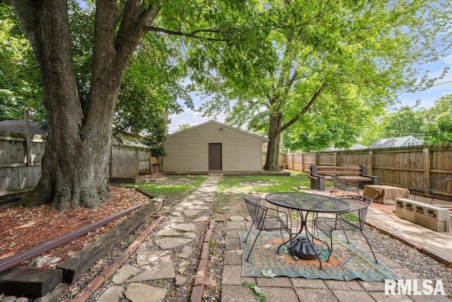 2446 16th Ave, Moline, IL 61265 - fenced backyard with a patio area, an outdoor structure, and outdoor dining space