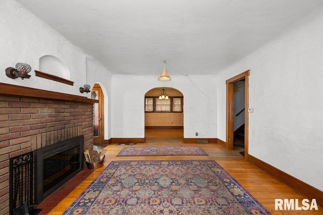 2446 16th Ave, Moline, IL 61265 - living area featuring wood finished floors, a fireplace, baseboards, and arched walkways