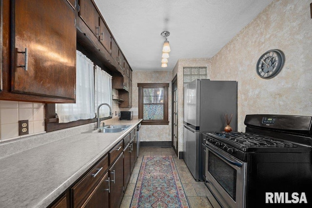 2446 16th Ave, Moline, IL 61265 - kitchen featuring gas stove, a sink, freestanding refrigerator, stone tile flooring, and dark brown cabinets