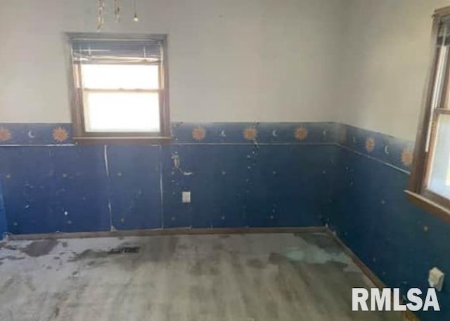 207 W Wilson St, New London, IA 52645 - unfurnished room with healthy amount of natural light and wood finished floors
