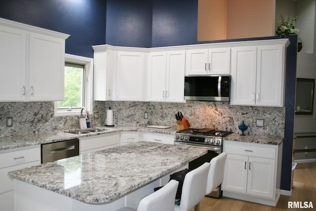 4011 Prairie Ln, Bettendorf, IA 52722 - kitchen featuring appliances with stainless steel finishes, a sink, backsplash, and light wood-type flooring