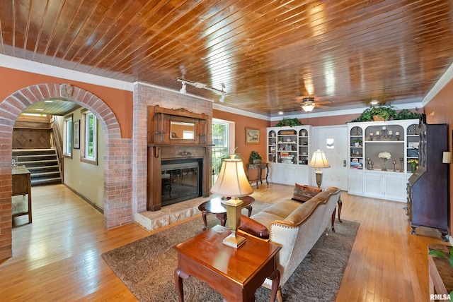 905 1st St, Camanche, IA 52730 - living area featuring a brick fireplace, healthy amount of natural light, light wood-style flooring, ornamental molding, and wooden ceiling