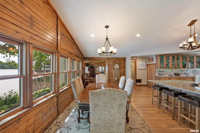905 1st St, Camanche, IA 52730 - dining area with a chandelier, light wood finished floors, lofted ceiling, recessed lighting, and wooden walls