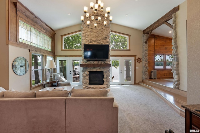 905 1st St, Camanche, IA 52730 - living area featuring a stone fireplace, french doors, high vaulted ceiling, a chandelier, and carpet