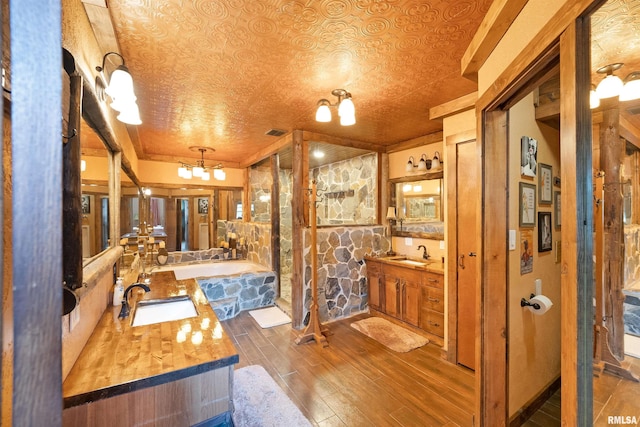 905 1st St, Camanche, IA 52730 - full bath featuring wood finished floors, two vanities, and a garden tub