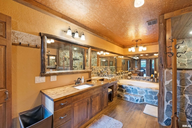 905 1st St, Camanche, IA 52730 - bathroom featuring hardwood / wood-style flooring, a bath, a textured wall, and vanity