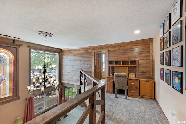 905 1st St, Camanche, IA 52730 - office space featuring a chandelier, a textured ceiling, wood walls, and light colored carpet