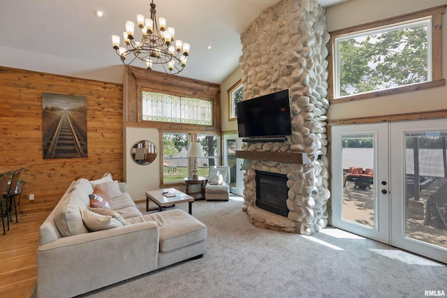 905 1st St, Camanche, IA 52730 - living room featuring a fireplace, healthy amount of natural light, wooden walls, a chandelier, and a towering ceiling